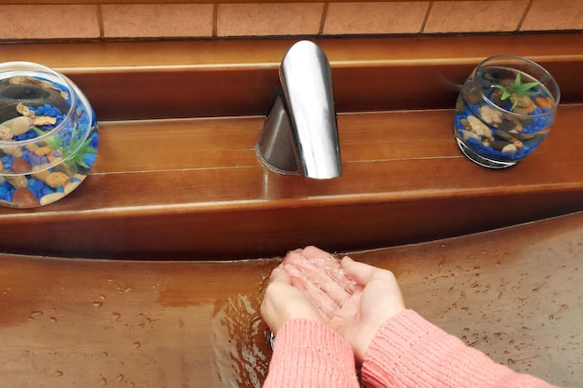 Młoda kobieta myje ręce w zlewie