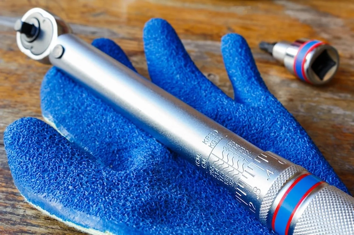 Klucz dynamometryczny i rękawica na stole