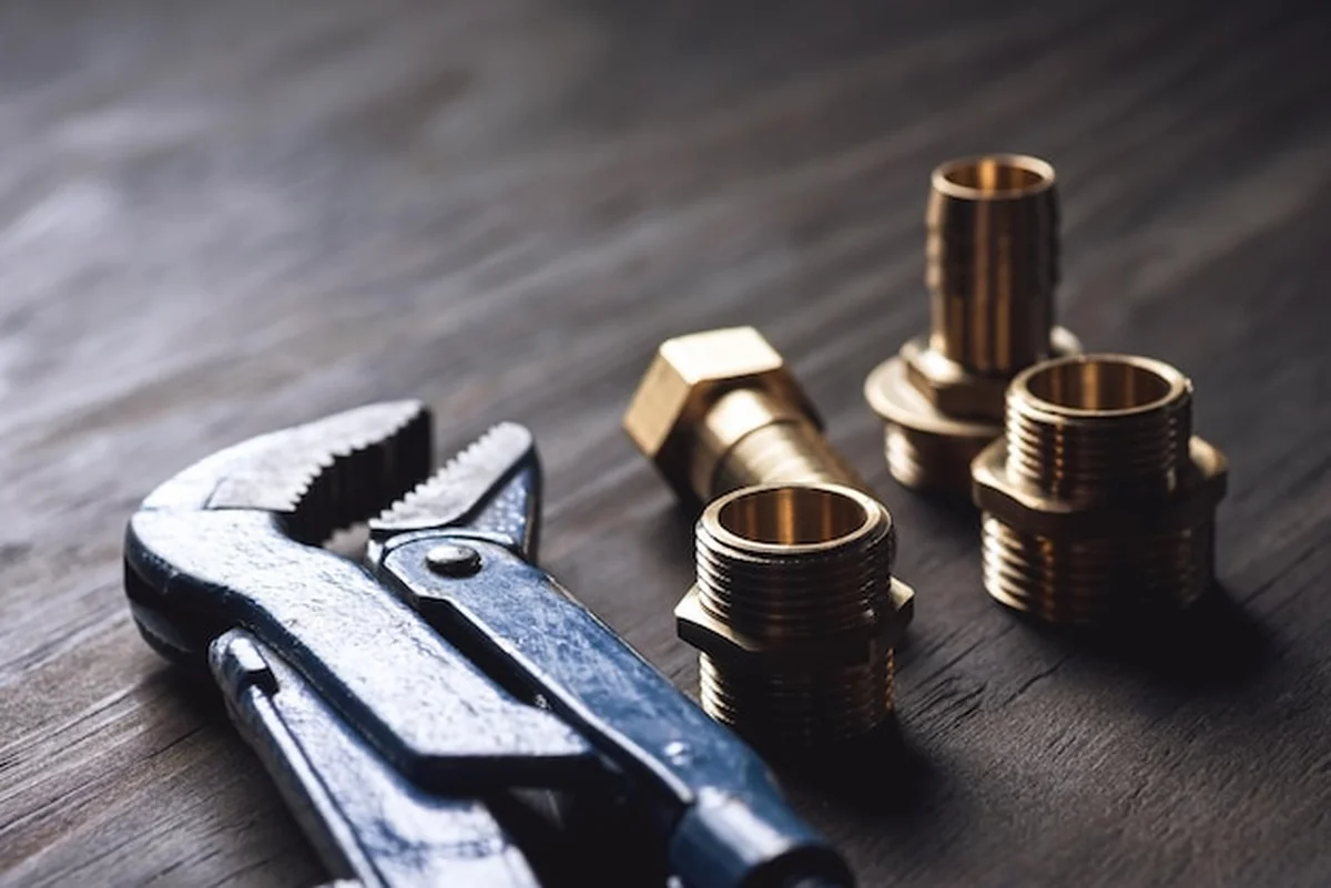 Różne klucze i złączki na drewnianym stole rustycznym