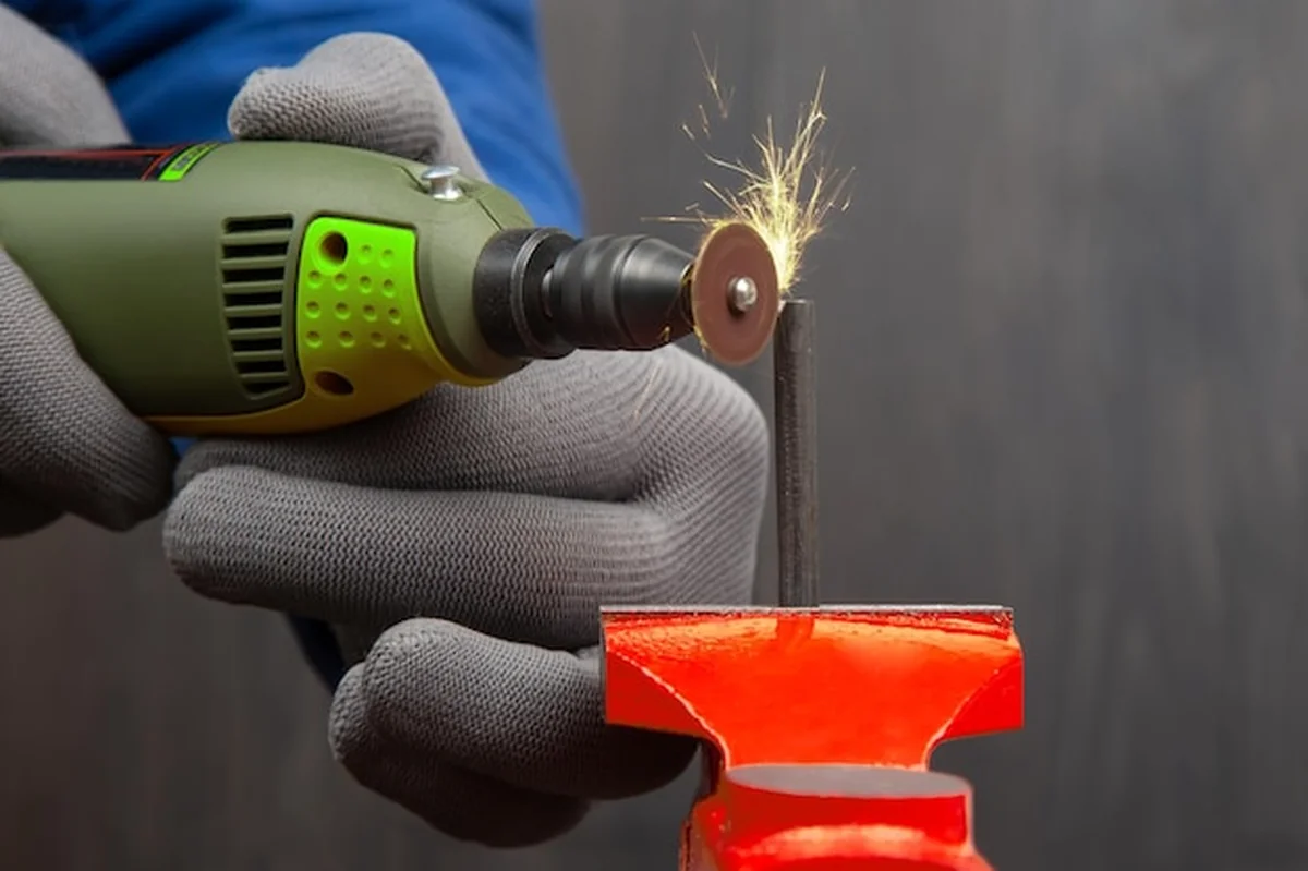 Pracownik przetwarza metal za pomocą wiertła grawerującego