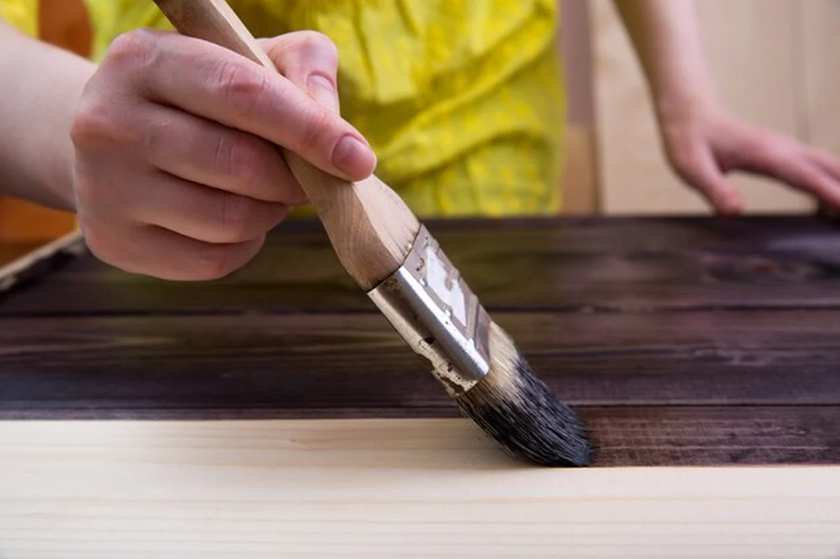 Barwienie jasnego drewna pędzlem w ciemnym kolorze