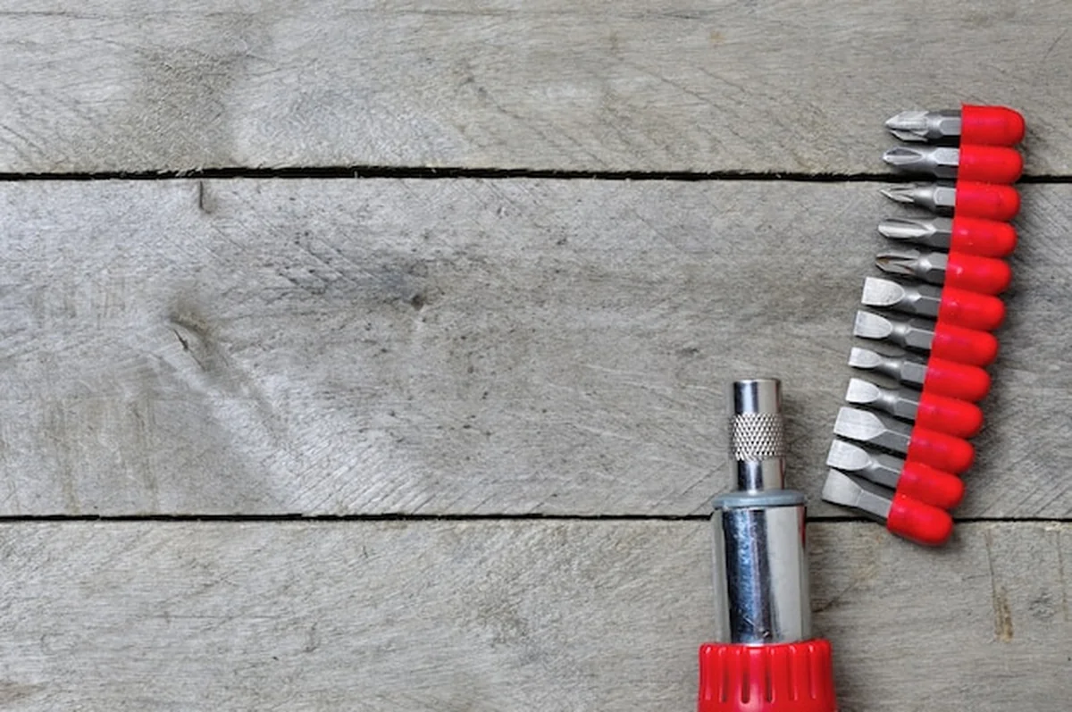 Śrubokręt i bity na drewnianym stole