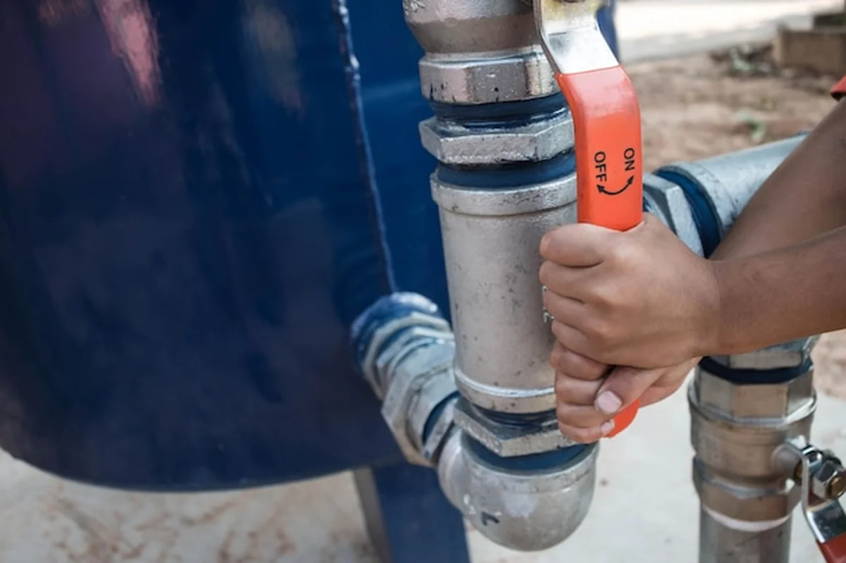 Ręce przycięte trzymają dźwignię rury wodociągowej