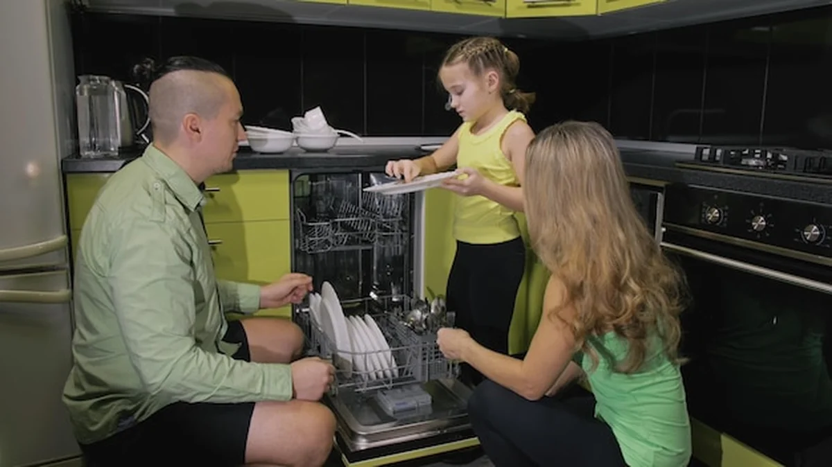 Rodzice uczą córkę obsługi zmywarki