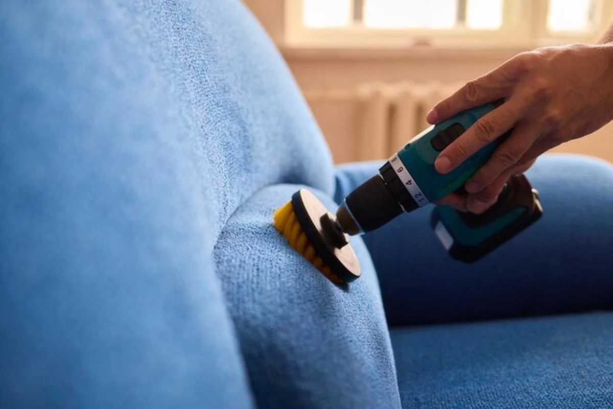 Piękna sofa czyszczona narzędziem, aby usunąć klej z tapicerki