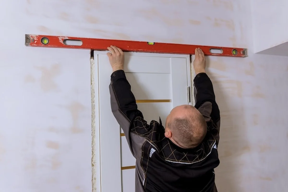 Mistrz sprawdza montaż drzwi podczas remontu mieszkania