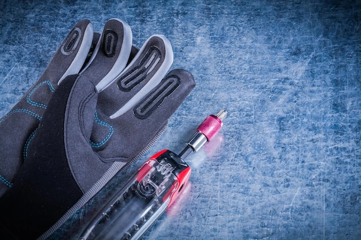 Zestaw narzędzi tkaniny rękawice ochronne na tle metalowe