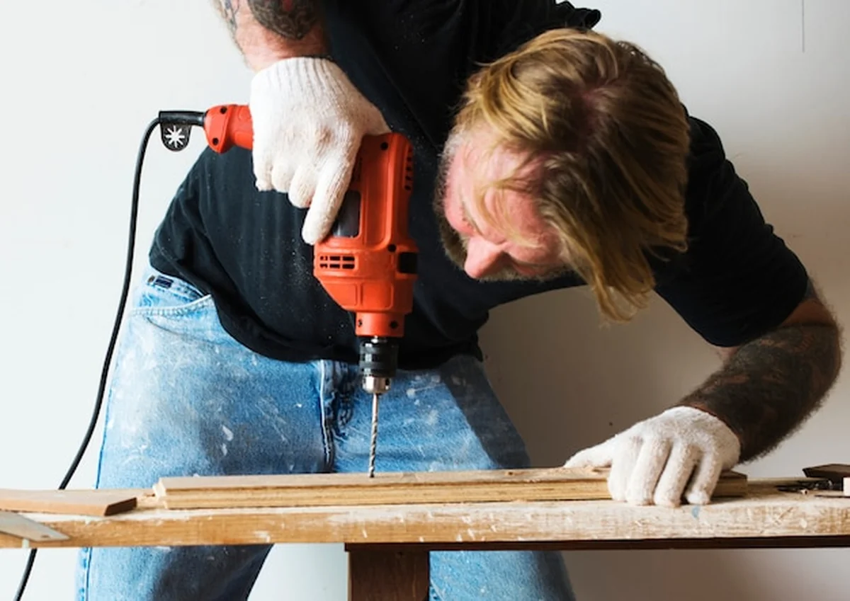 Stolarz używa wiertarki do drewna