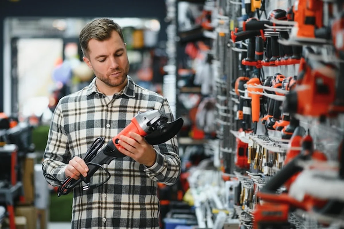 Mężczyzna wybiera narzędzie elektryczne w sklepie z narzędziami