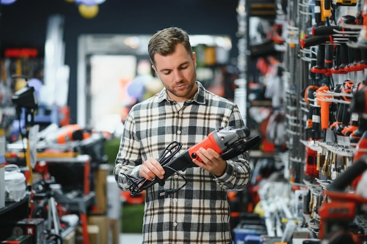 Mężczyzna wybiera narzędzie elektryczne w sklepie z narzędziami