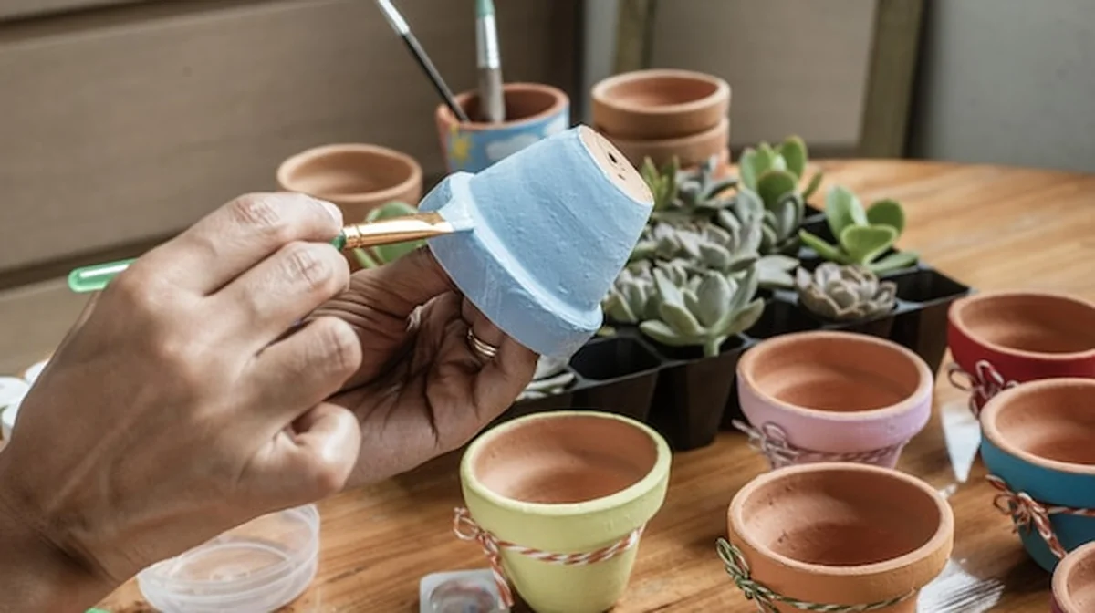 Ręce latynoskiej Mulatki malujące gliniane doniczki