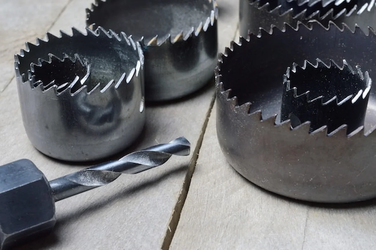 Zestaw starych koron do wiercenia w drzewie na tle deski drewna