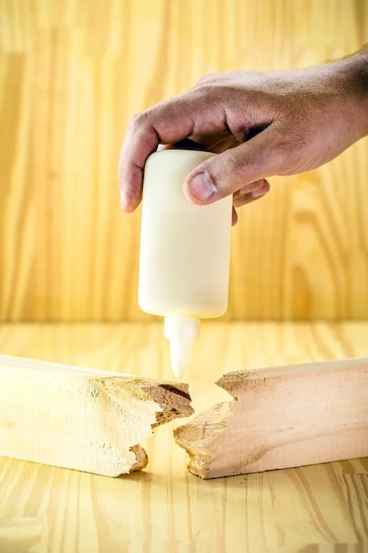 Stolarz nakładający klej do drewna na deskę