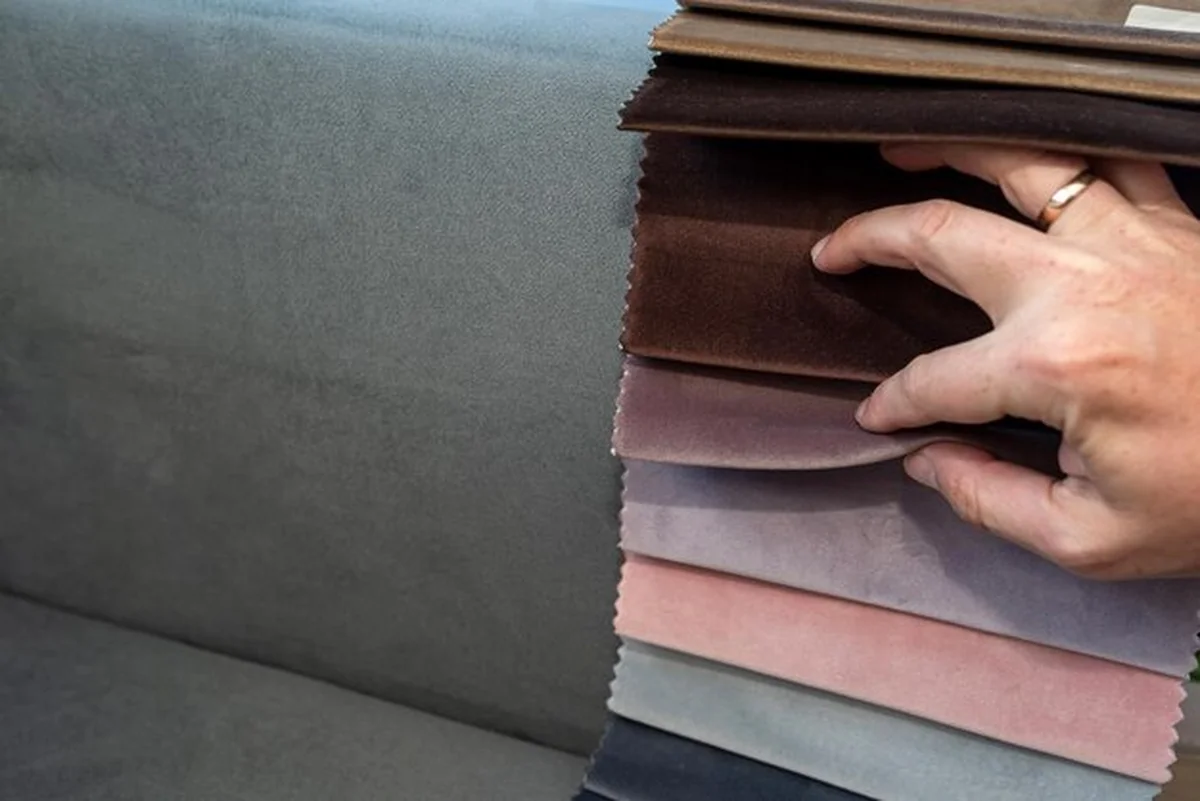 Klient wybiera tkaninę spośród kolorowych próbek z bliska