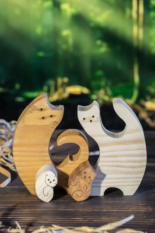 Drewniane puzzle rodziny kotów na tle lasu