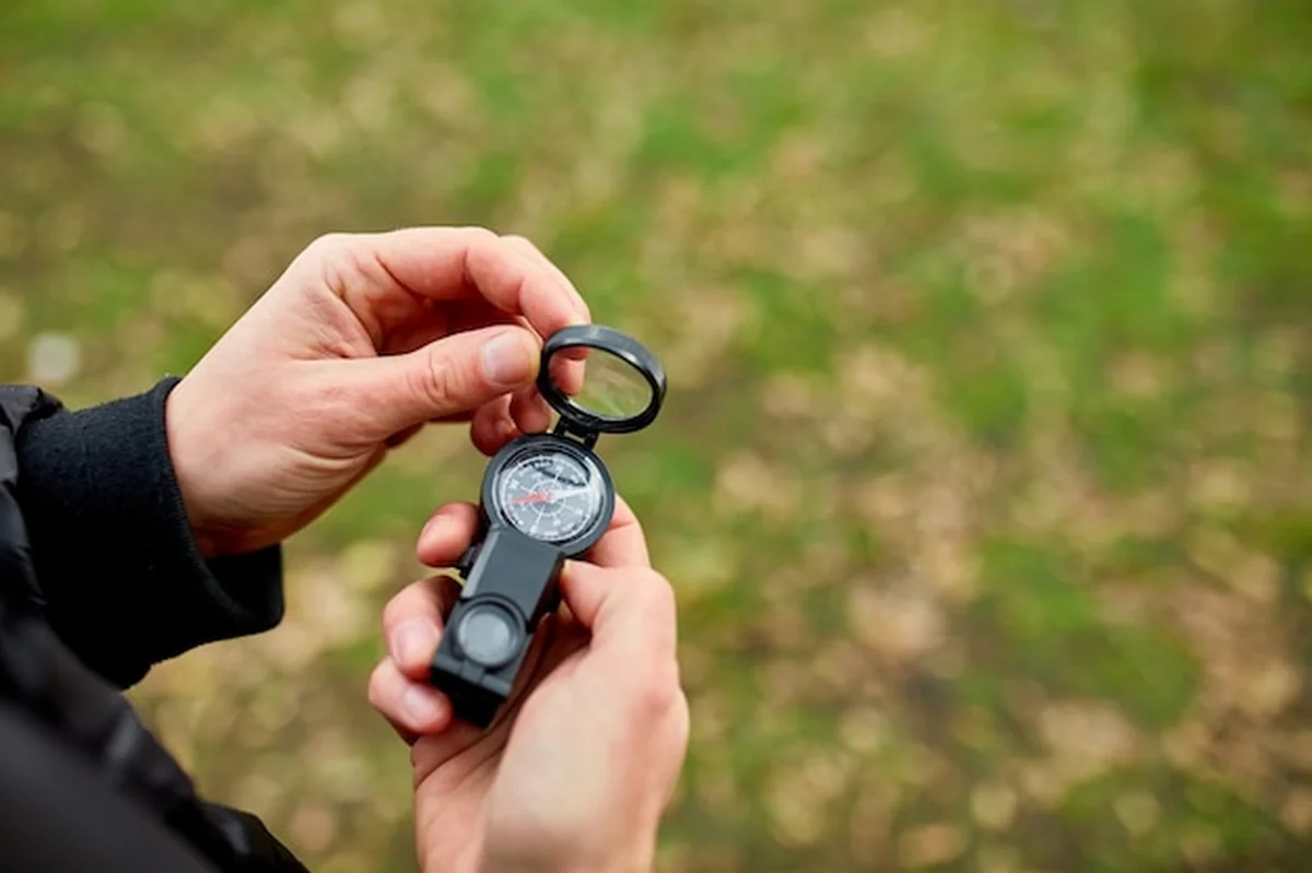 Zbliżenie dłoni człowieka podróżnika z kompasem na tle gór natury