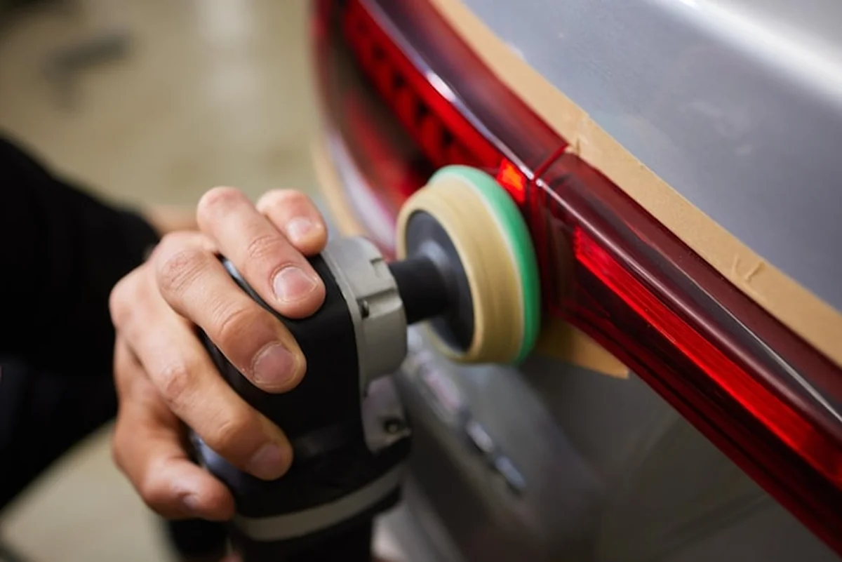 Osoba polerująca reflektor samochodowy maszyną