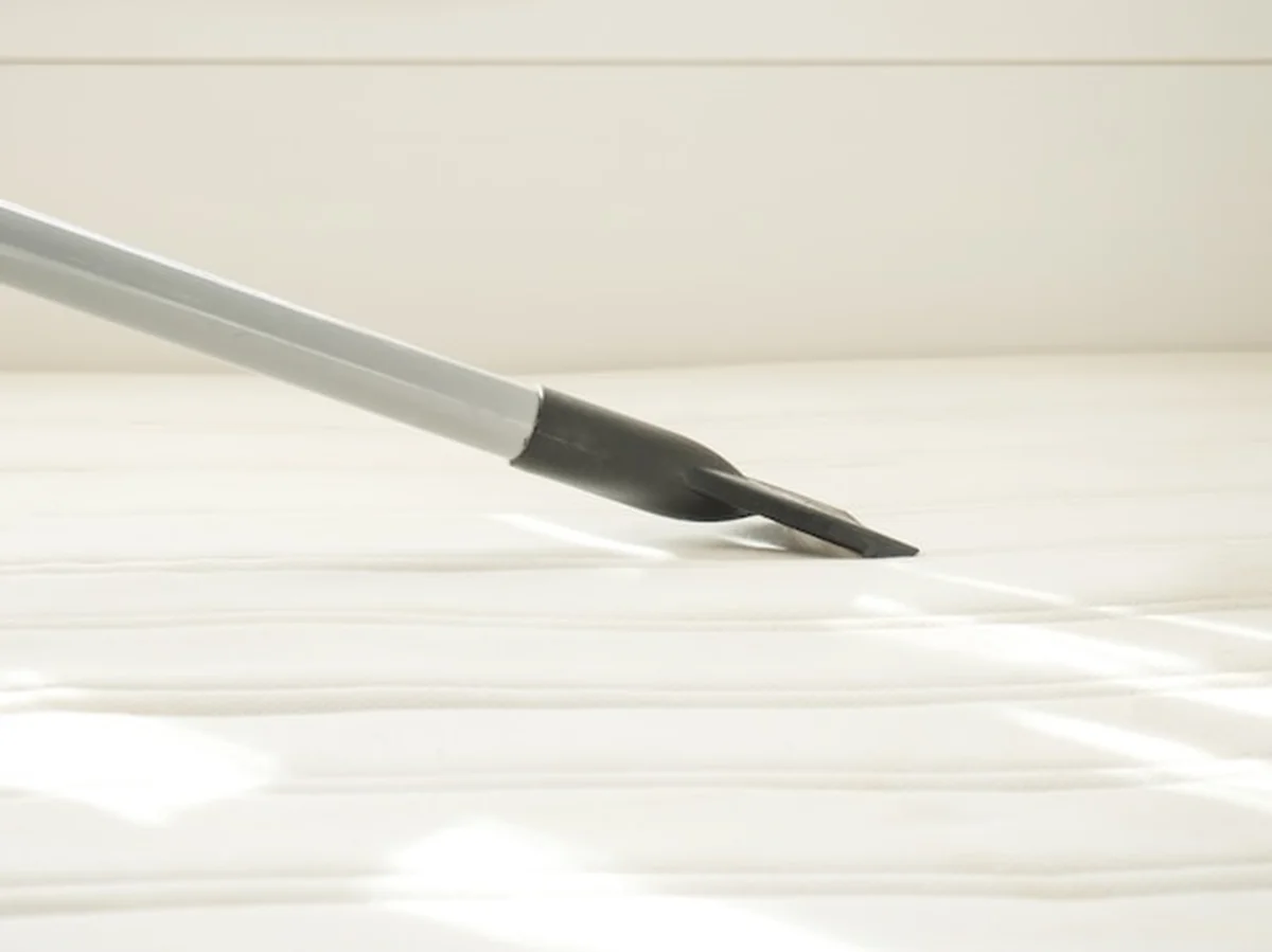 Czyszczenie materaca odkurzaczem ze śmieci i wełny, zbliżenie