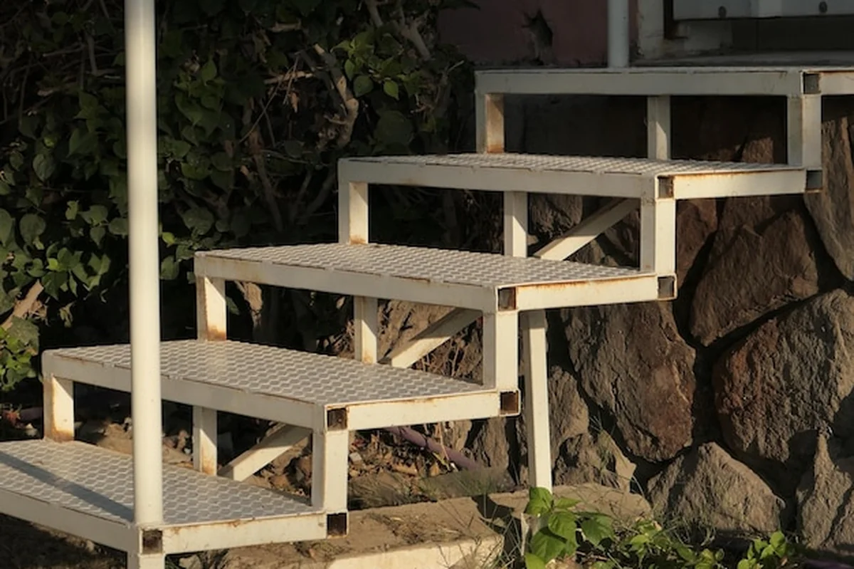 Metalowe schody na kamiennej ścianie