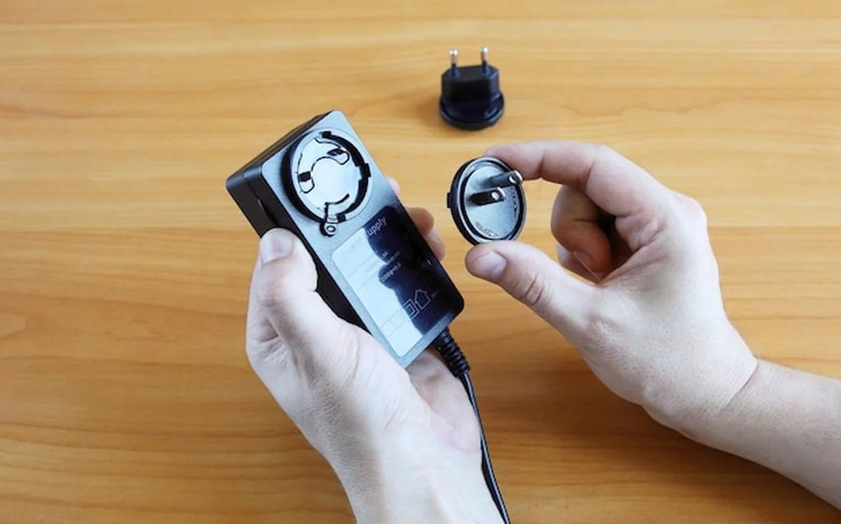 Ludzkie ręce trzymają wtyczkę zasilacza