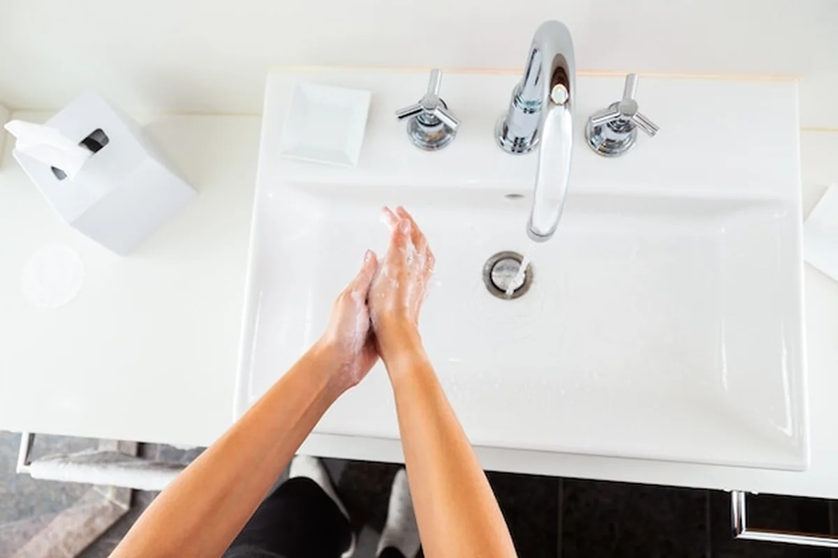 Kobieta myje ręce pod bieżącą wodą z góry
