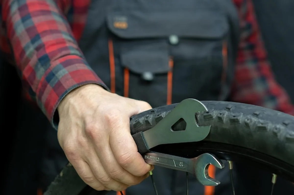 Mechanik trzymający narzędzia i koło rowerowe w warsztacie